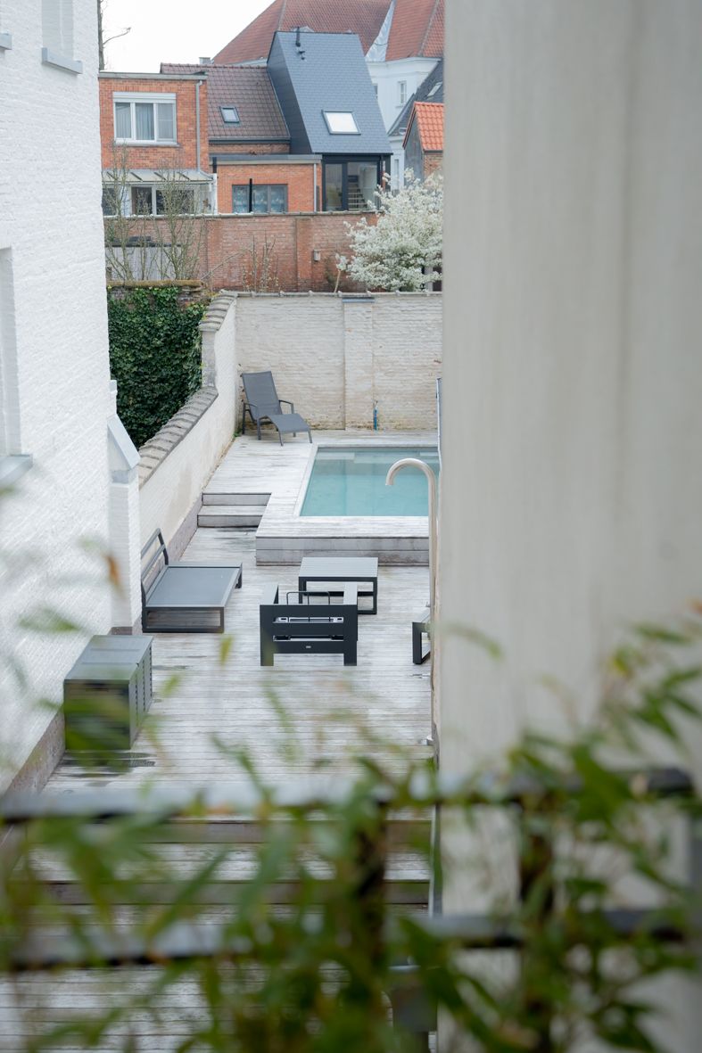 Moderne tuin met zwembad en architecturale kolommen